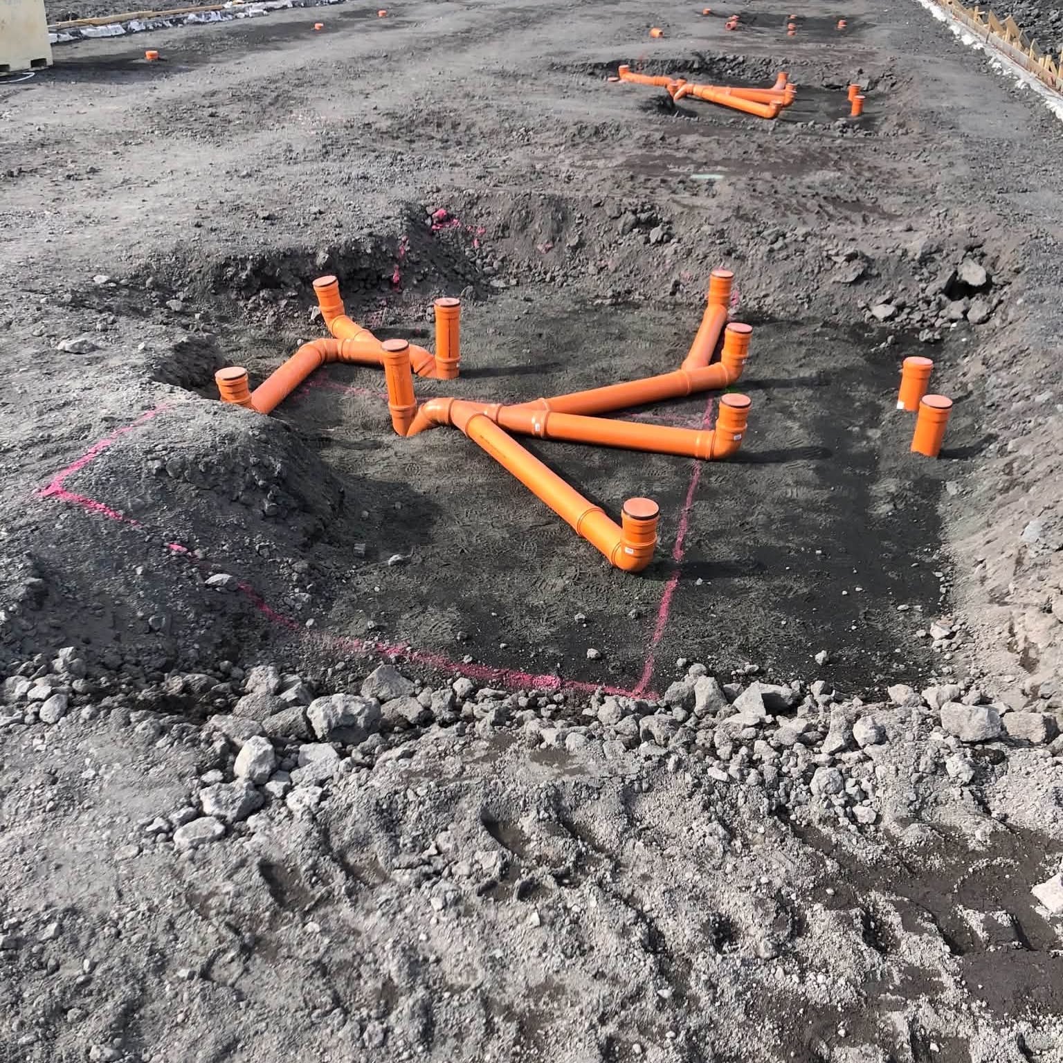Skólplagnir úr PVC lagðar og tengdar í uppgröfnum jarðvegi.